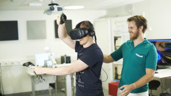 Bildet viser en behandler sammen med en pasient med VR-briller